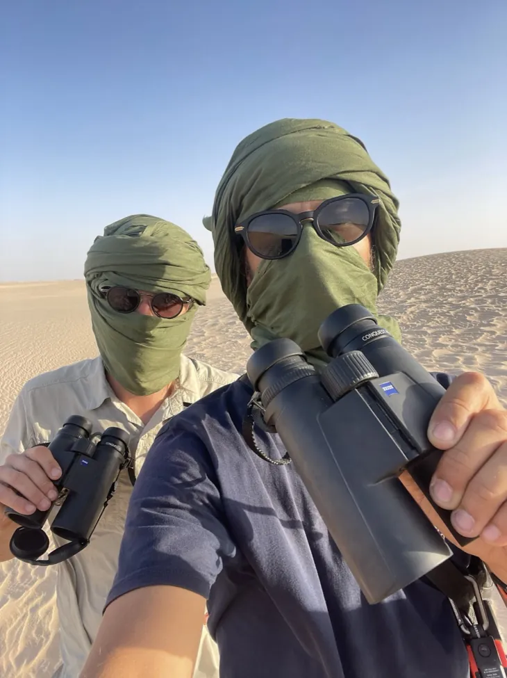Axel und Ario mit grünen Kopftüchern und Ferngläsern in den Dünen Mauretaniens